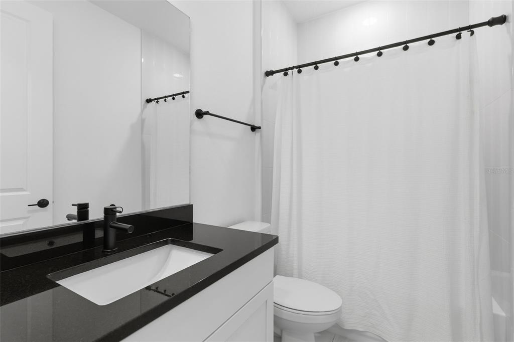 19912 Bridgetown Loop Venice, FL 34293 - Photo 29 of 49 a bathroom with a granite countertop sink toilet and shower