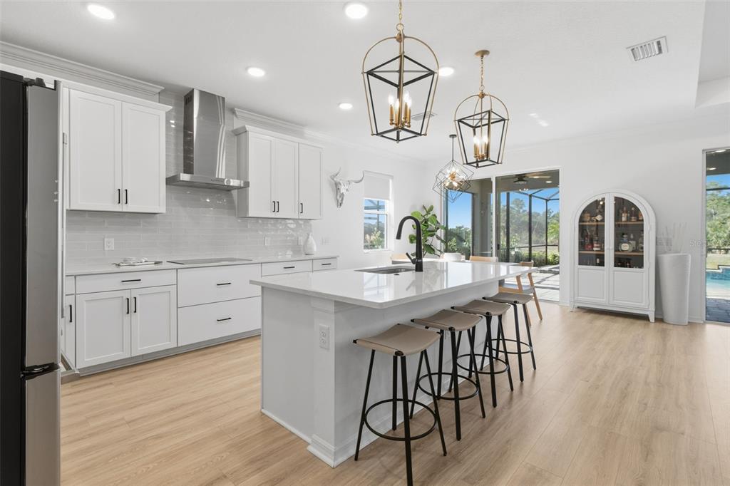 19912 Bridgetown Loop Venice, FL 34293 - Photo 6 of 49 a kitchen with stainless steel appliances kitchen island granite countertop a wooden floor and white cabinets