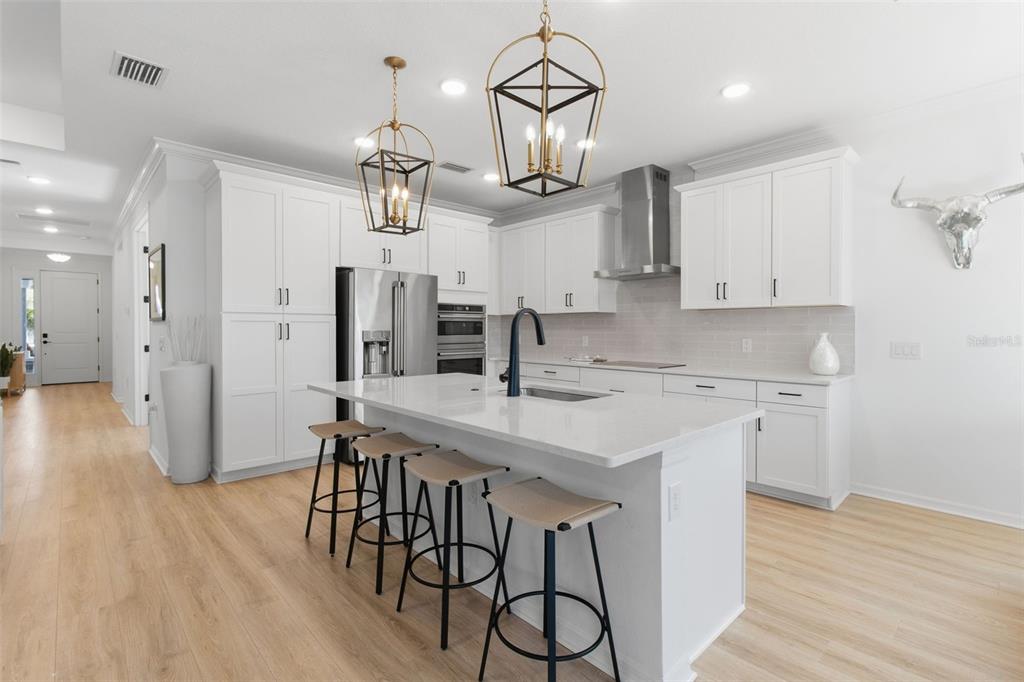 19912 Bridgetown Loop Venice, FL 34293 - Photo 7 of 49 a kitchen with stainless steel appliances a dining table chairs sink and refrigerator
