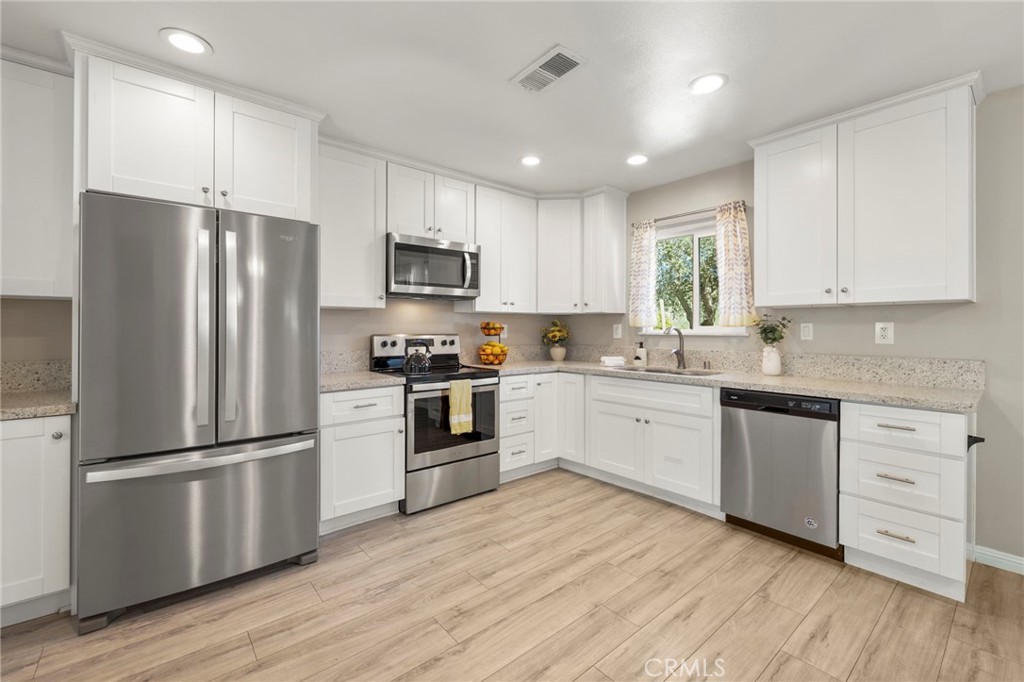 6472 Rainbow Heights Road Rainbow, CA 92028 - Photo 48 of 65 a kitchen with cabinets stainless steel appliances a sink and a window