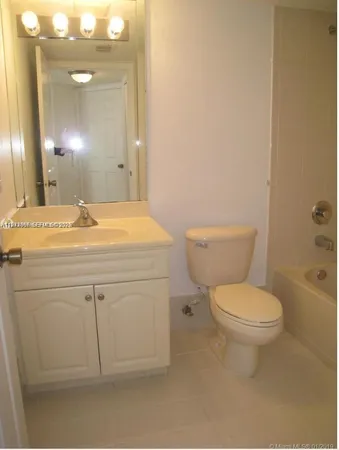 a bathroom with a sink mirror vanity and toilet