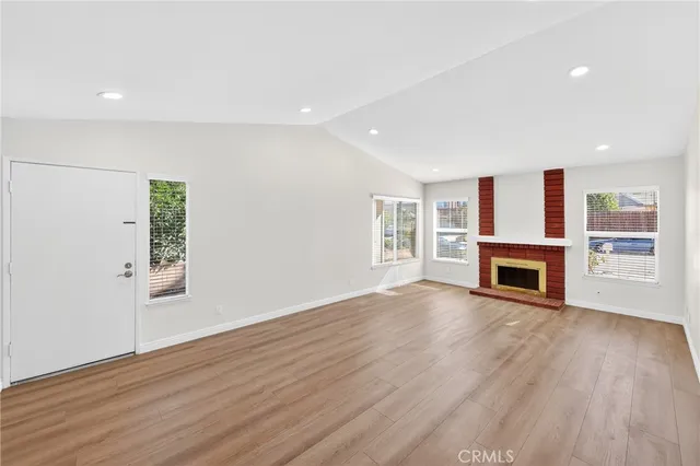 a view of a livingroom with a fireplace wooden floor and window