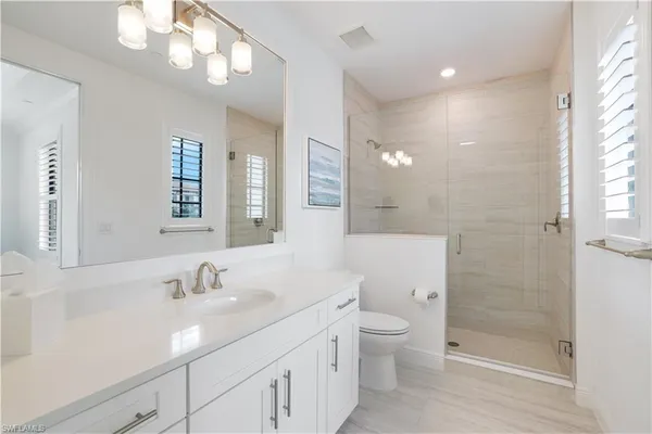 a bathroom with a double vanity sink toilet and shower