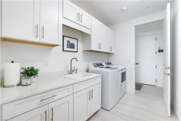 a view of cabinets a sink and dishwasher in a white cabinet