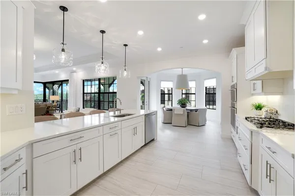 a large kitchen with kitchen island a large counter space a sink stainless steel appliances and cabinets