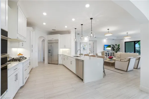 a large white kitchen with lots of counter space wooden floor and appliances
