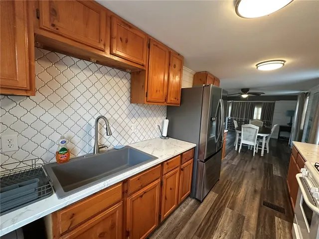 a kitchen with stainless steel appliances granite countertop a sink refrigerator and cabinets