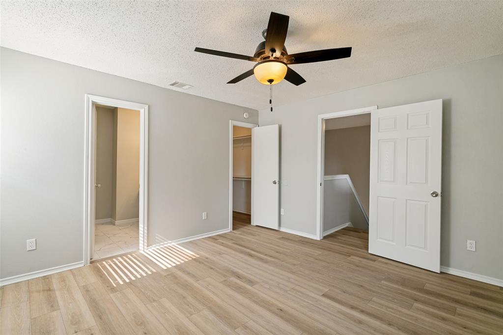 1712 East Peters Colony Road Carrollton, TX 75007 - Photo 20 of 25 Spacious room featuring wood-finish flooring, light grey wall paint, and a ceiling fan with integrated lighting