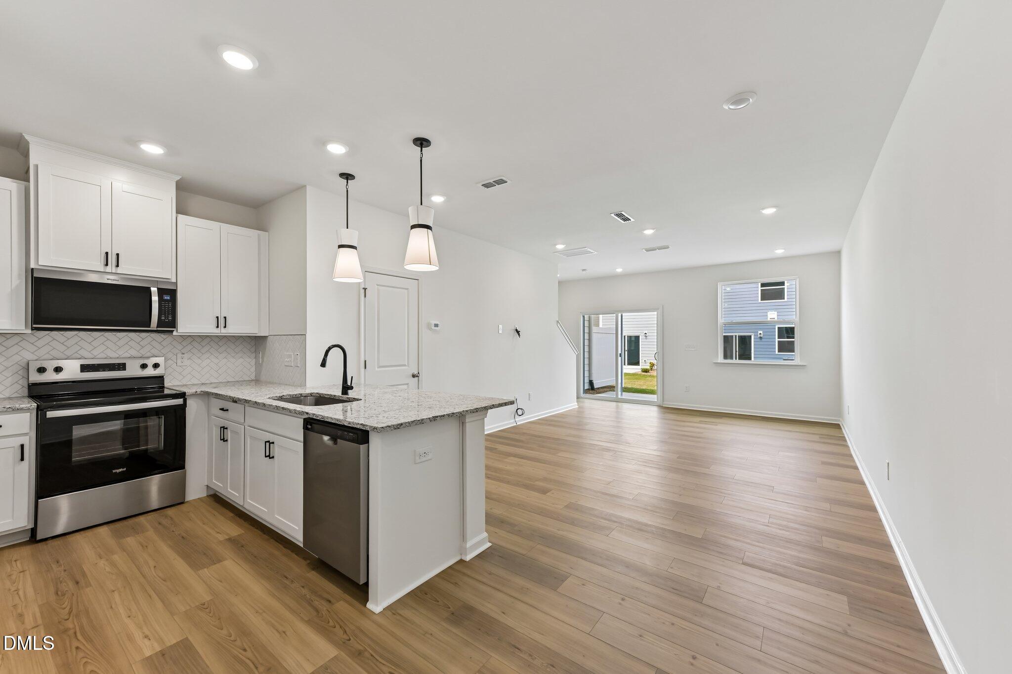 3019 Chrys Street Durham, NC 27704 - Photo 13 of 46 a large kitchen with stainless steel appliances granite countertop a stove and a sink
