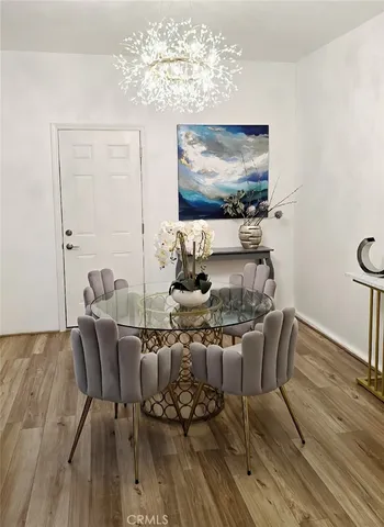 a dining room with furniture a chandelier and wooden floor