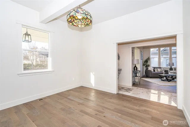 a view of a livingroom with wooden floor and a large window