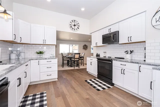 a kitchen with stainless steel appliances a sink cabinets and a window