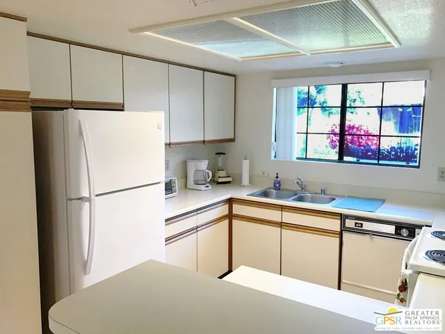 a kitchen with stainless steel appliances a refrigerator sink and cabinets