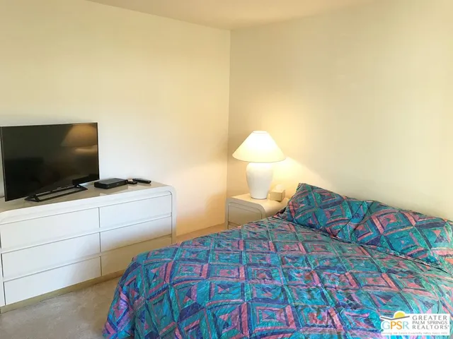 a bedroom with a bed and flat screen tv