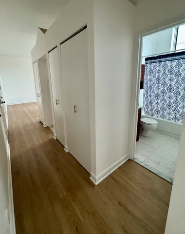 a view of a hallway with wooden floor and entryway