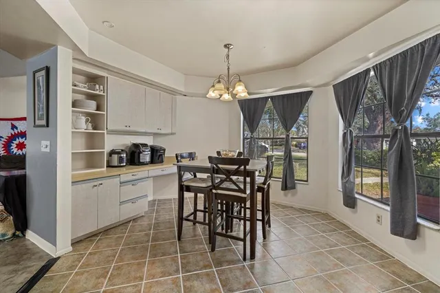 a kitchen with stainless steel appliances a stove a table and chair