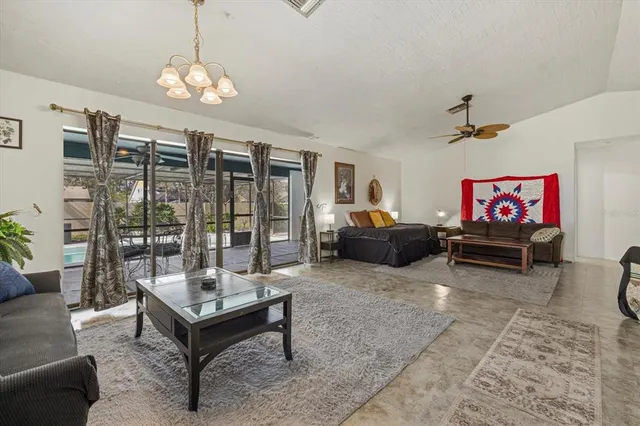 a living room with furniture a chandelier and a flat screen tv