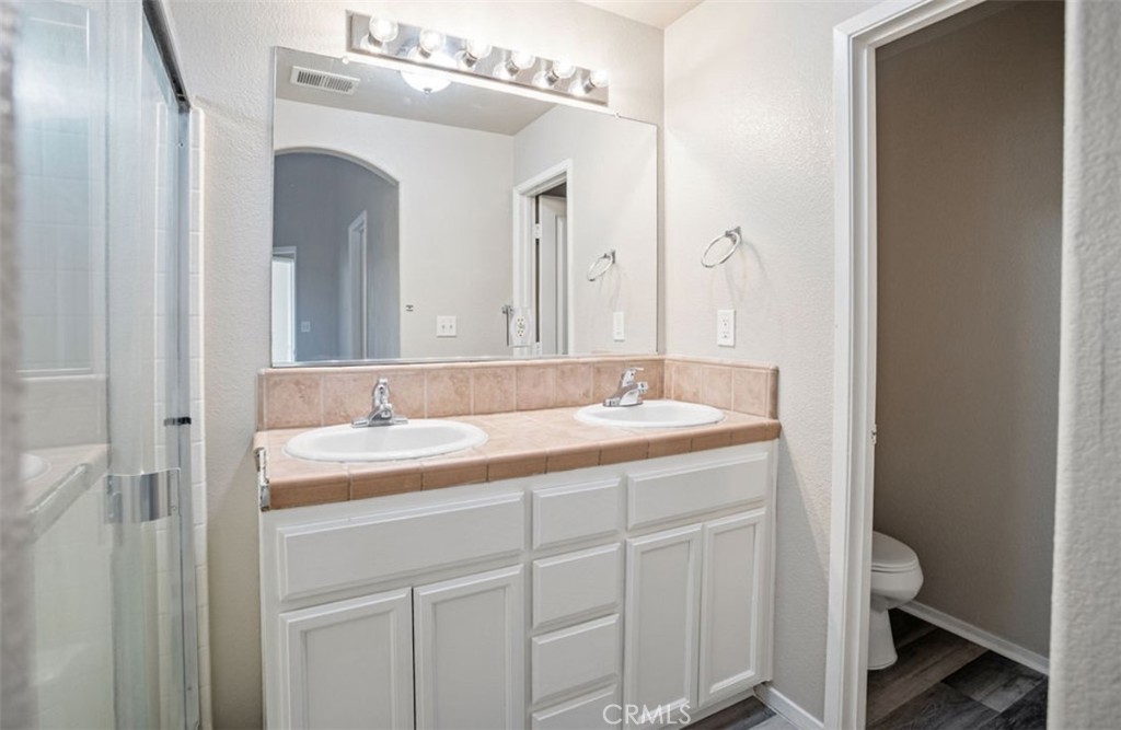 2139 Chesler Street Merced, CA 95348 - Photo 13 of 19 a bathroom with a sink a toilet and a mirror