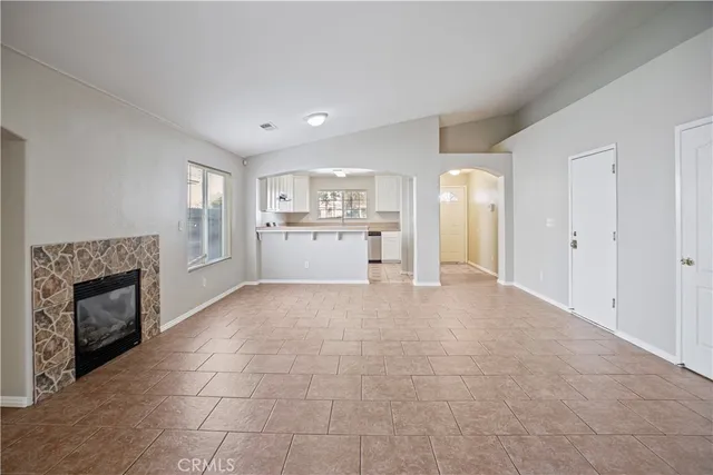 a large white kitchen with a sink and a fireplace