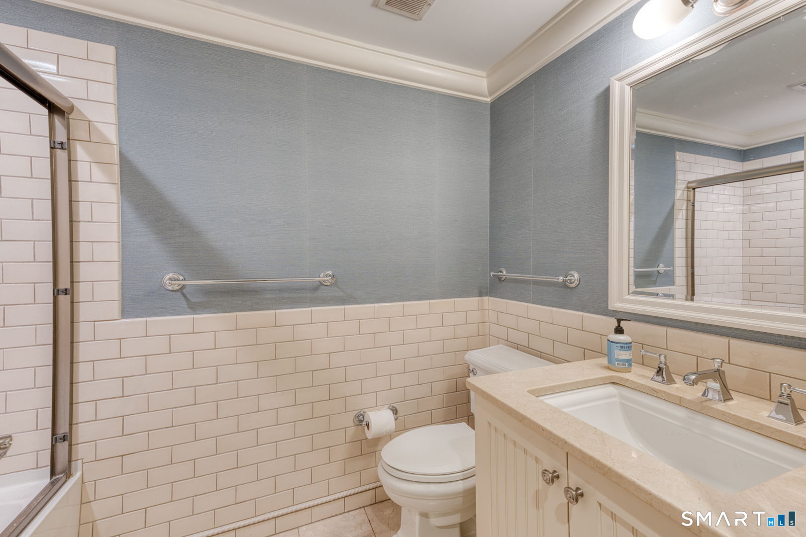 85 Memorial Road, Unit 411 West Hartford, CT 06107 - Photo 16 of 24 a bathroom with a sink a toilet and mirror