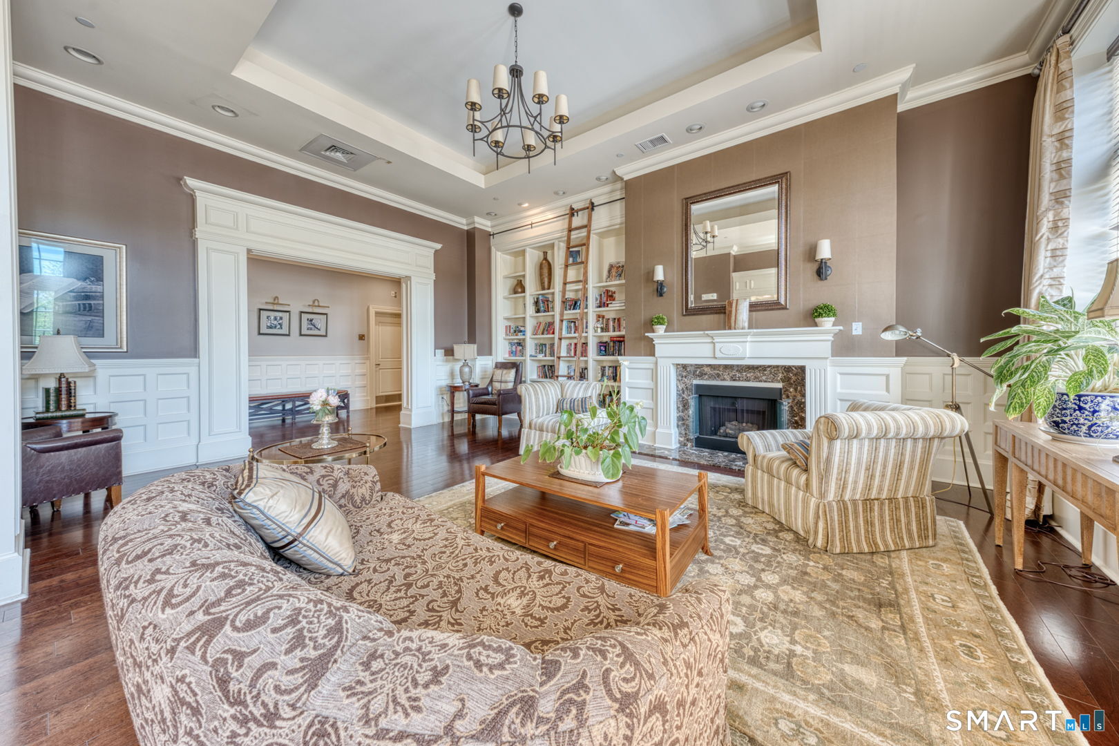 85 Memorial Road, Unit 411 West Hartford, CT 06107 - Photo 20 of 24 a living room with furniture a fireplace and a chandelier