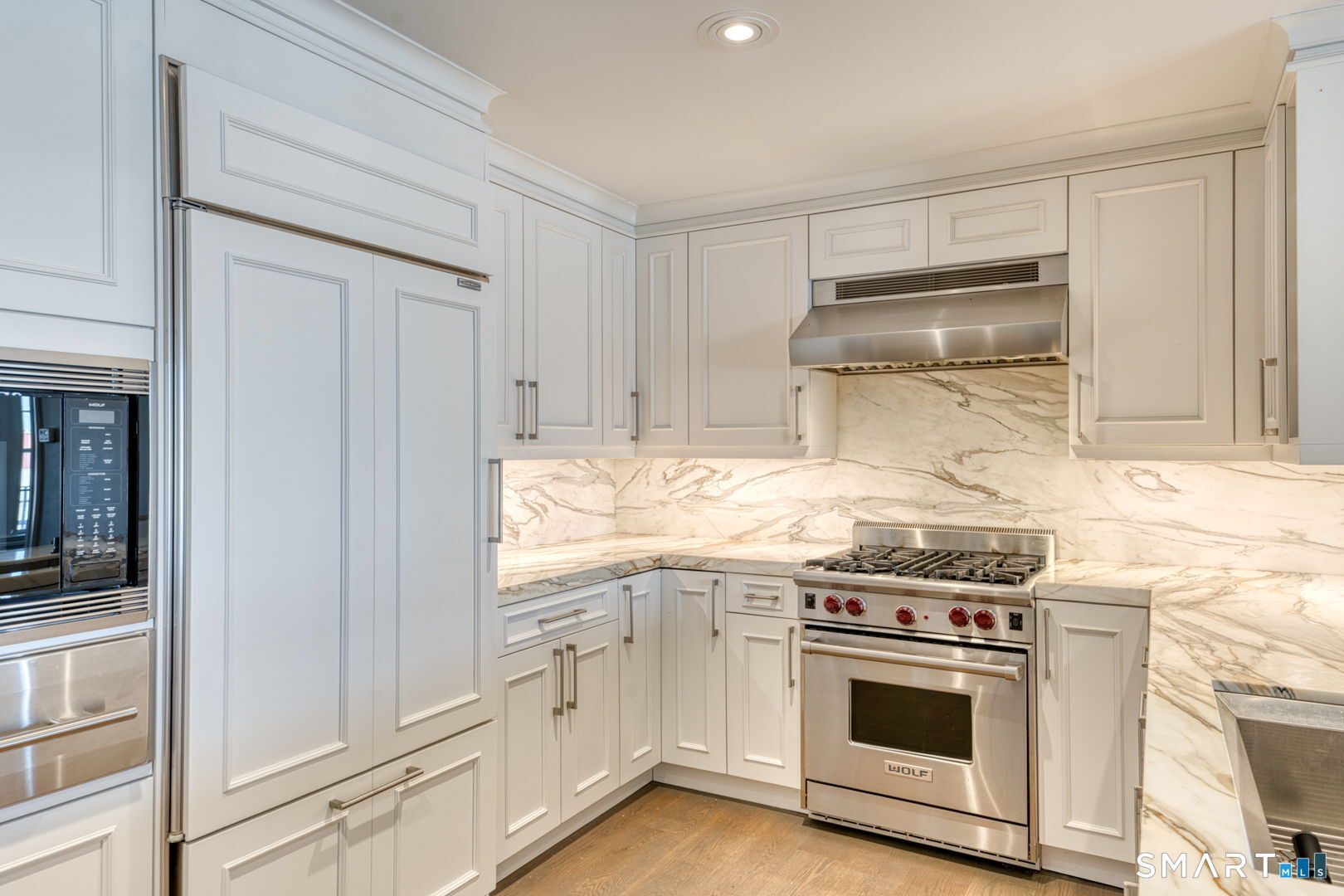 85 Memorial Road, Unit 411 West Hartford, CT 06107 - Photo 6 of 24 a kitchen with granite countertop white cabinets and white appliances