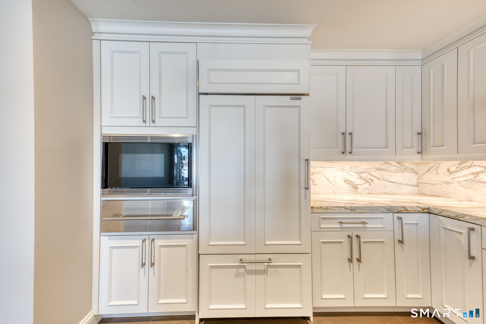 85 Memorial Road, Unit 411 West Hartford, CT 06107 - Photo 7 of 24 a view of kitchen with white cabinets and a refrigerator