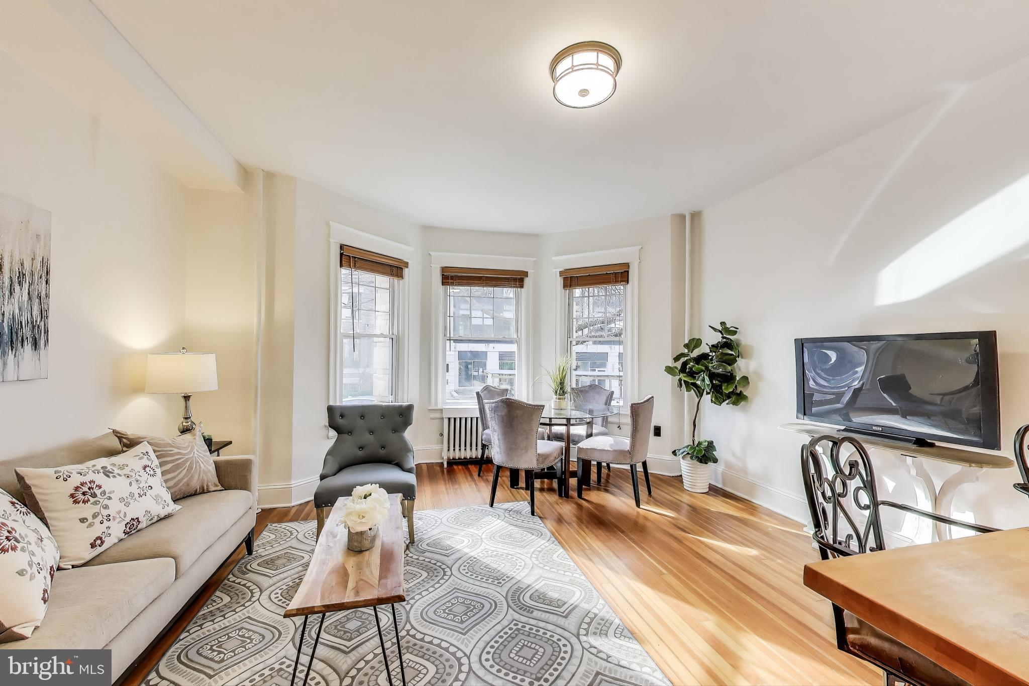 1791 Lanier Place Northwest, Unit 2 Washington, DC 20009 - Photo 13 of 30 a living room with furniture floor to ceiling window and a flat screen tv