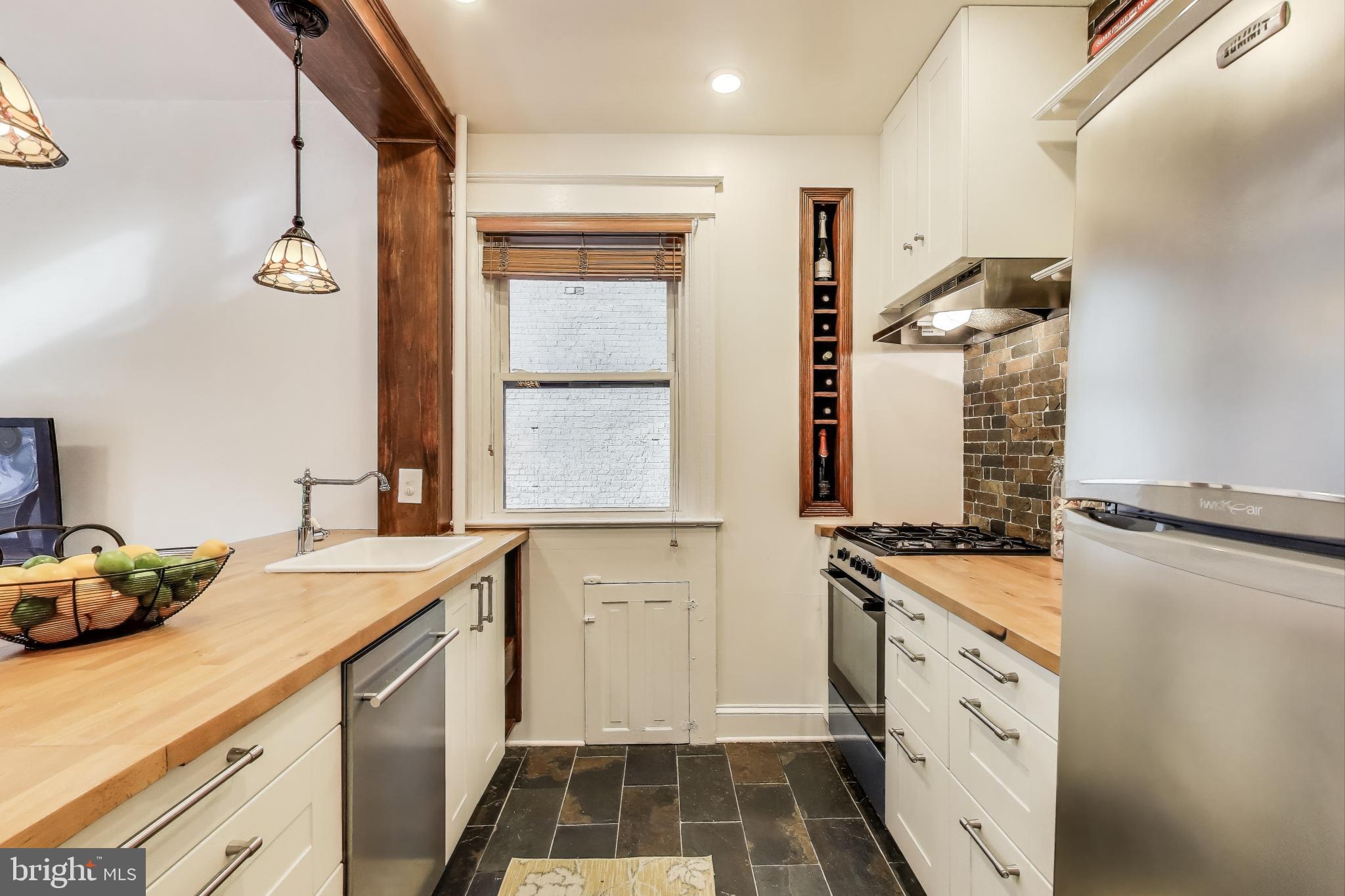 1791 Lanier Place Northwest, Unit 2 Washington, DC 20009 - Photo 20 of 30 a kitchen with granite countertop a sink stove and cabinets