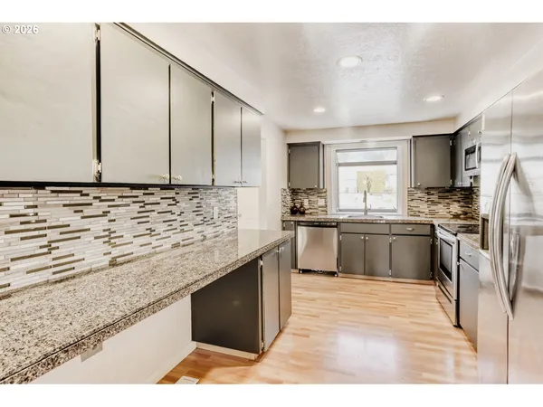 a kitchen with granite countertop a refrigerator and cabinets