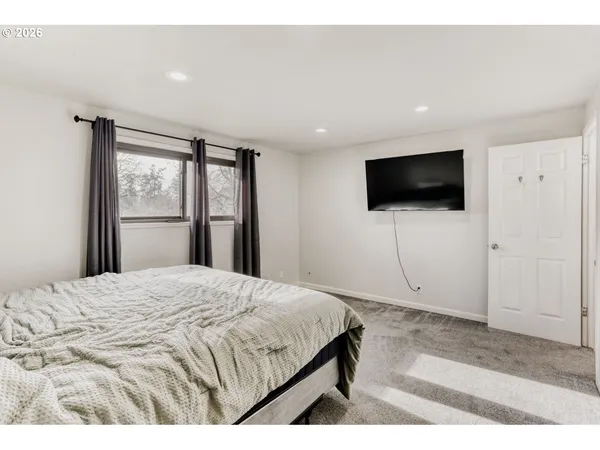 a bedroom with a bed and a flat screen tv