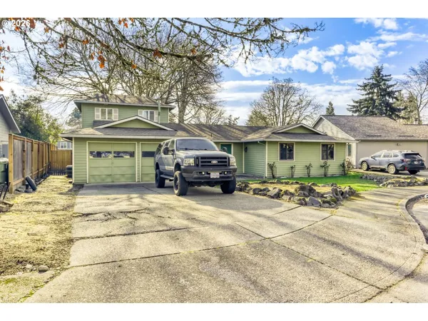 a front view of a house with a garden and car parked