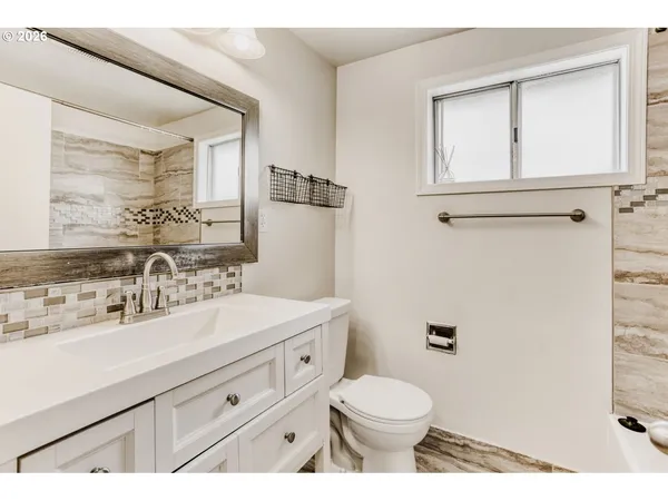 a bathroom with a sink a toilet and a mirror