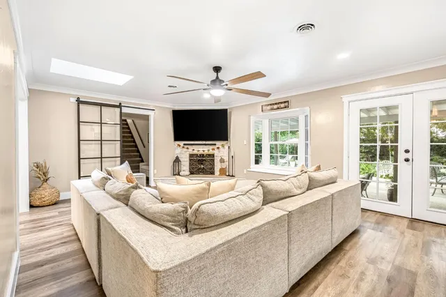 a living room with furniture fireplace and a large window