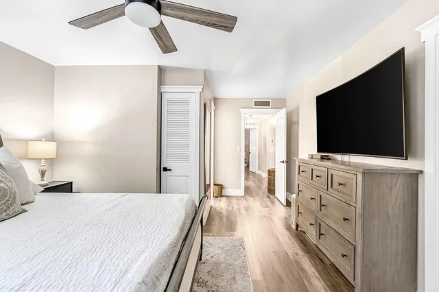 a bedroom with a flat screen tv on the dresser and a flat screen tv