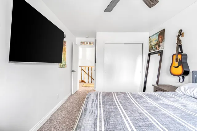 a bedroom with a bed and painting on the wall
