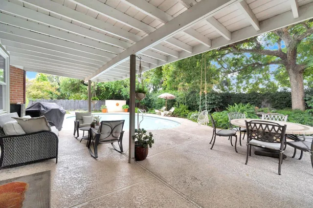 a living room with patio furniture and a backyard
