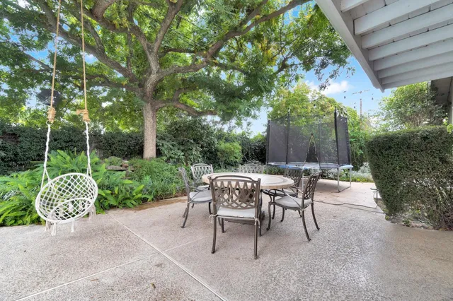 a view of a chairs and table in backyard