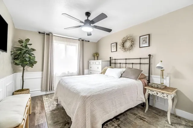 a bedroom with a large bed and a potted plant