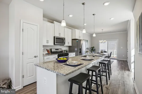 a kitchen with a sink a microwave and wooden floor