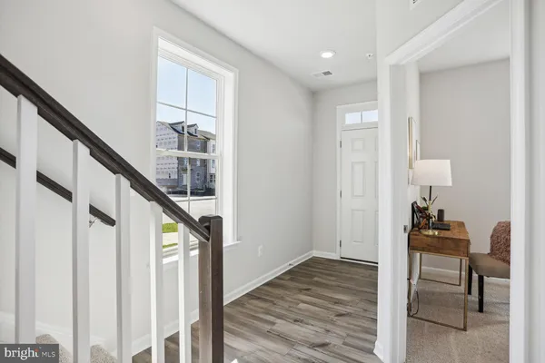 a view of entryway and hall with wooden floor