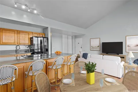 a living room with furniture kitchen view and a large window