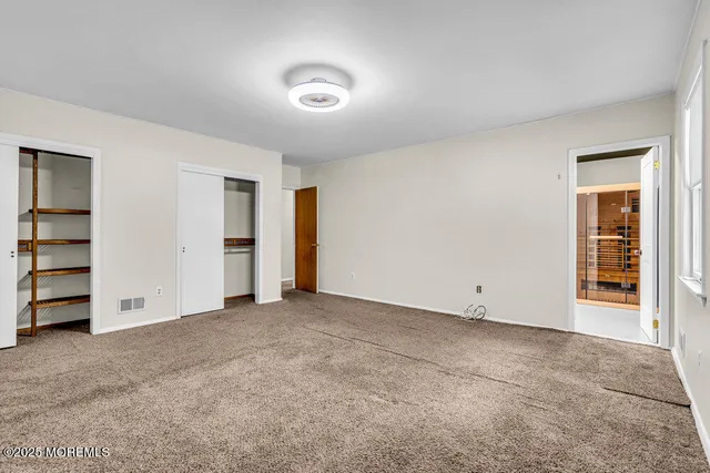 an empty room with a closet and cabinet