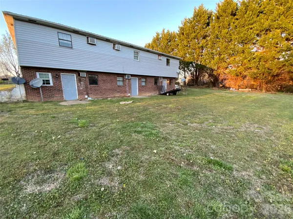 a view of a house with a big yard and large tree