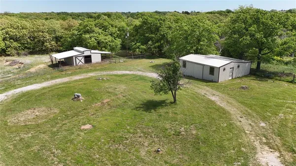 an aerial view of residential houses with outdoor space and trees