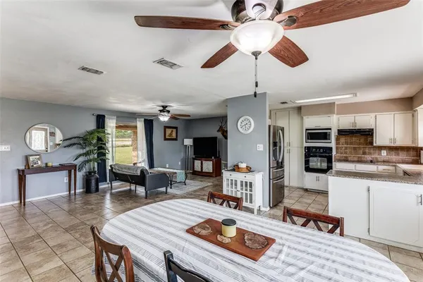 a living room with furniture a flat screen tv and kitchen view