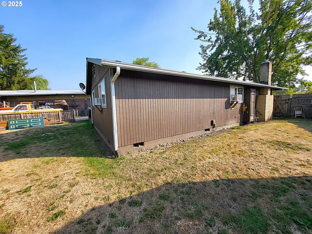 a backyard of a house with garage and barbeque oven