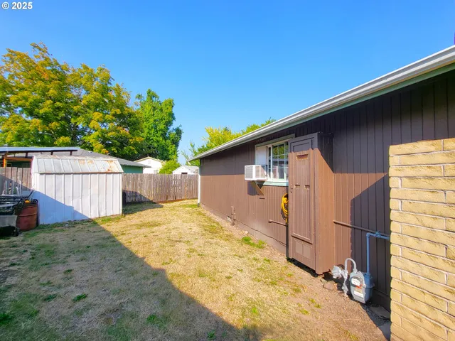 a backyard of a house with plants and wooden fence