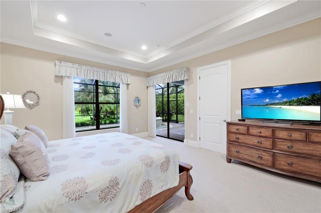 7598 Moorgate Point Way Naples, FL 34113 - Photo 12 of 33 a spacious bedroom with a bed and a flat screen tv