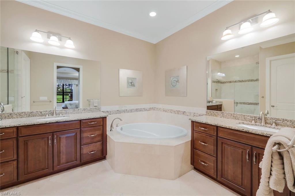 7598 Moorgate Point Way Naples, FL 34113 - Photo 13 of 33 a bathroom with a granite countertop double vanity sink a mirror and a bathtub